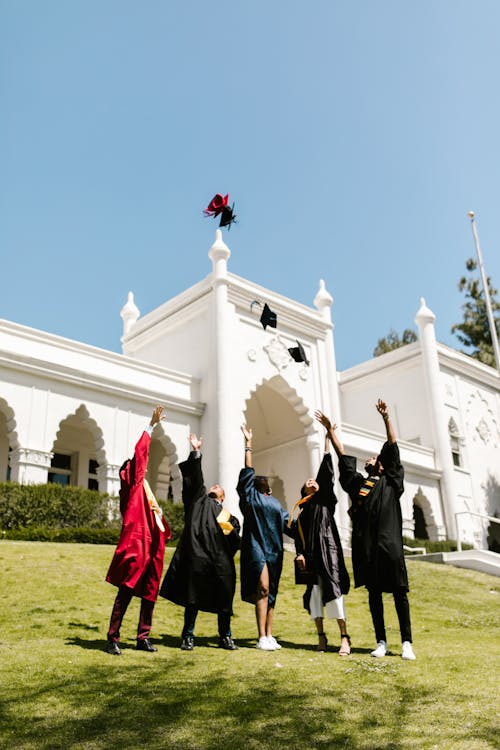 Free Students Throwing their Graduate Caps into the Air Stock Photo