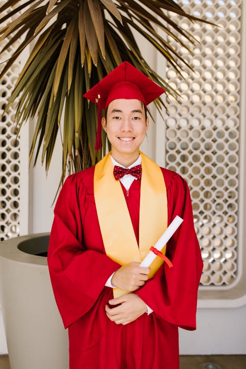 Free A Man in Red Graduation Gown Smiling Stock Photo